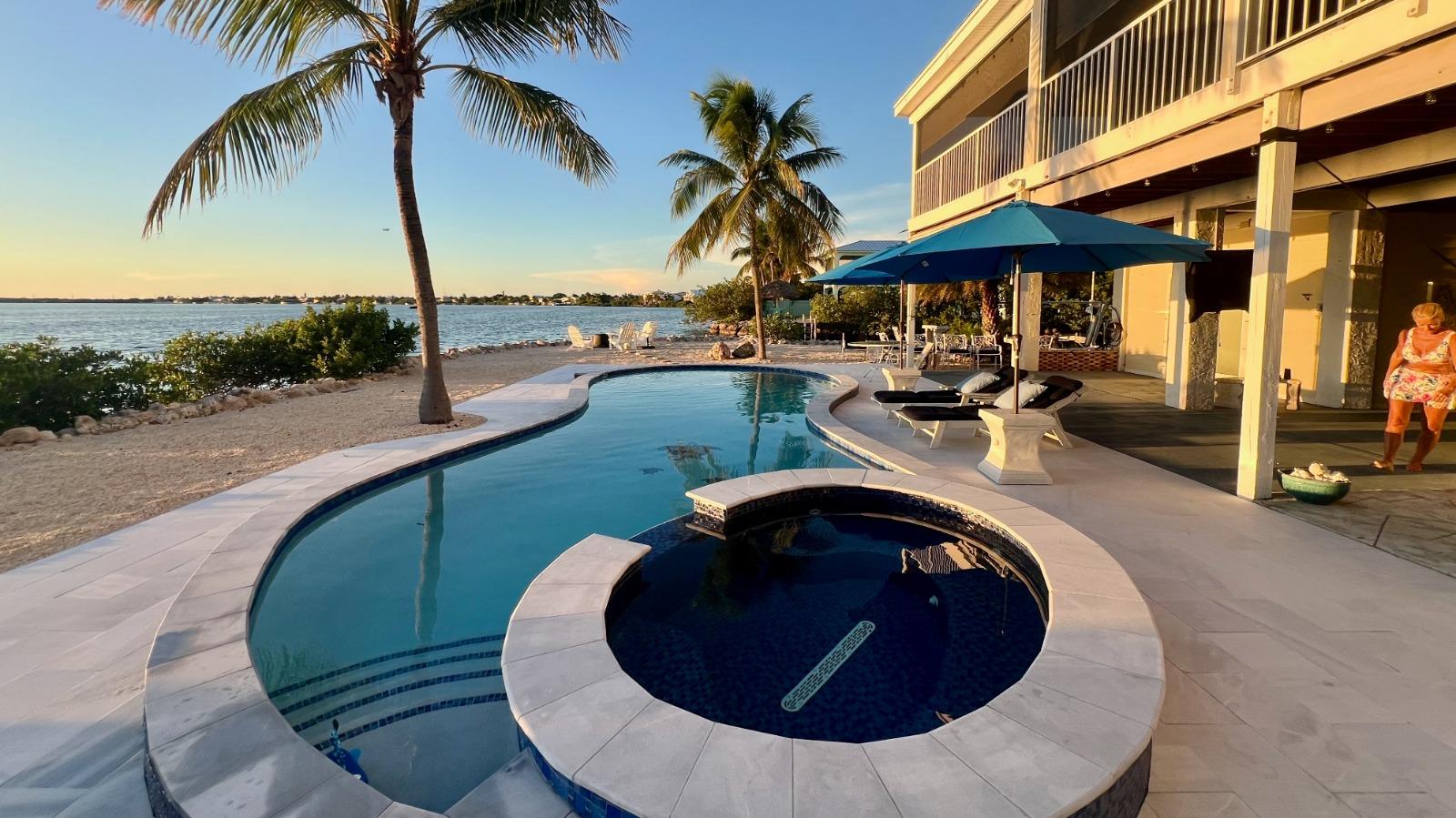 Luxury Lower Keys vacation rental featuring a private waterfront pool and spa with ocean views at sunset.